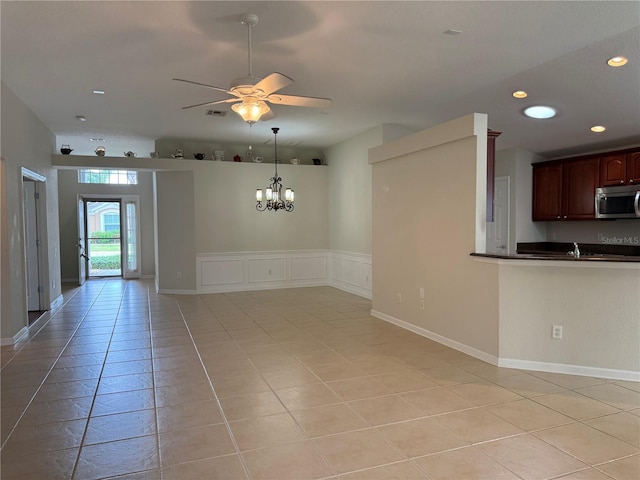541 Arena Dr, Davenport, FL 33837 - kitchen featuring stainless steel microwave, dark countertops, a ceiling fan, light tile patterned flooring, and recessed lighting
