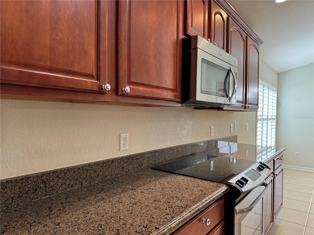 541 Arena Dr, Davenport, FL 33837 - kitchen featuring stainless steel appliances, light tile patterned floors, and dark stone countertops