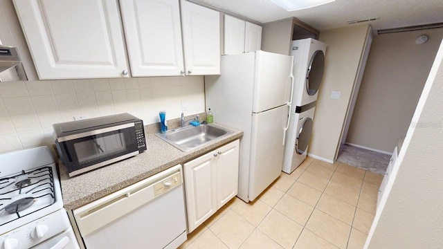 145 Oyster Bay Cir Unit 200, Altamonte Springs, FL 32701 - kitchen featuring white appliances, stacked washer / dryer, a sink, and white cabinets