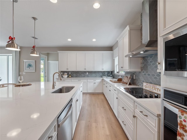 4413 Lions Gate Ave, Clermont, FL 34711 - kitchen featuring wall chimney range hood, stainless steel appliances, white cabinetry, decorative backsplash, and light wood-type flooring
