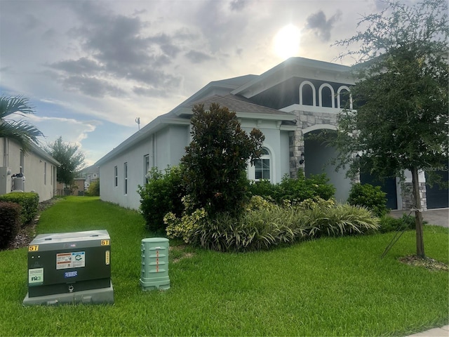 4413 Lions Gate Ave, Clermont, FL 34711 - view of property exterior featuring stucco siding, a lawn, and stone siding