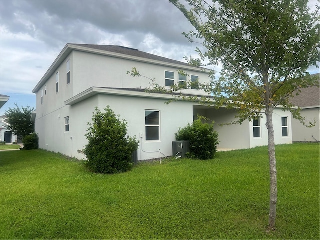 4413 Lions Gate Ave, Clermont, FL 34711 - rear view of property with stucco siding and a yard