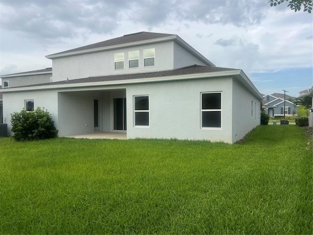 4413 Lions Gate Ave, Clermont, FL 34711 - rear view of property with stucco siding, a patio, a lawn, and a shingled roof