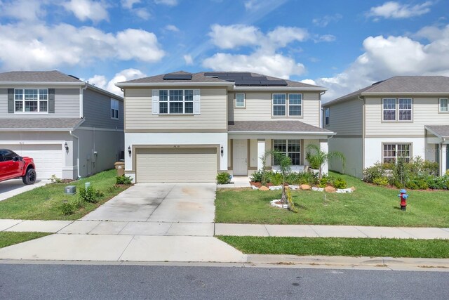 7639 Agrigento St, Clermont, FL 34714 - traditional-style house with a front lawn, a garage, concrete driveway, roof mounted solar panels, and stucco siding