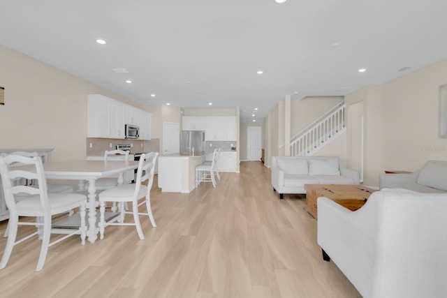 7639 Agrigento St, Clermont, FL 34714 - living area with light wood-type flooring, stairs, and recessed lighting