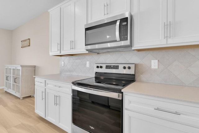 7639 Agrigento St, Clermont, FL 34714 - kitchen featuring appliances with stainless steel finishes, light countertops, white cabinetry, and tasteful backsplash