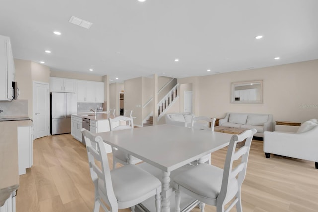7639 Agrigento St, Clermont, FL 34714 - dining area with light wood-style flooring, recessed lighting, and stairway