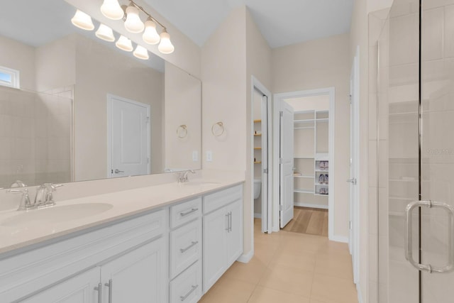 7639 Agrigento St, Clermont, FL 34714 - bathroom with double vanity, tiled shower, tile patterned floors, and a walk in closet