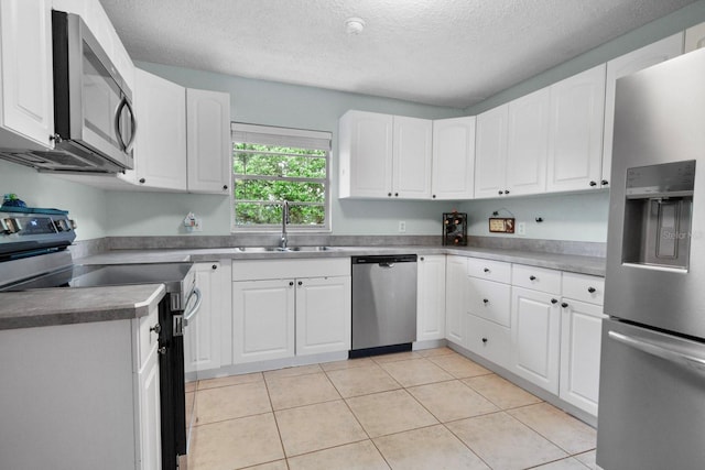 12434 Sullivan Rd, Clermont, FL 34715 - kitchen featuring appliances with stainless steel finishes, a textured ceiling, white cabinets, and light tile patterned floors