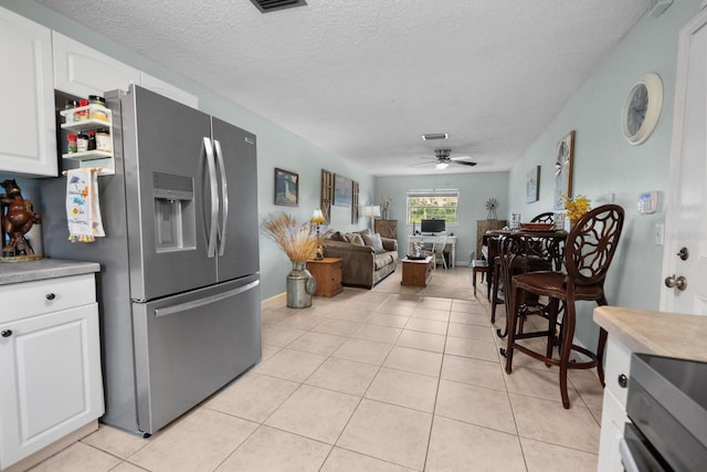 12434 Sullivan Rd, Clermont, FL 34715 - kitchen with stainless steel refrigerator with ice dispenser, white cabinetry, ceiling fan, light tile patterned floors, and a textured ceiling
