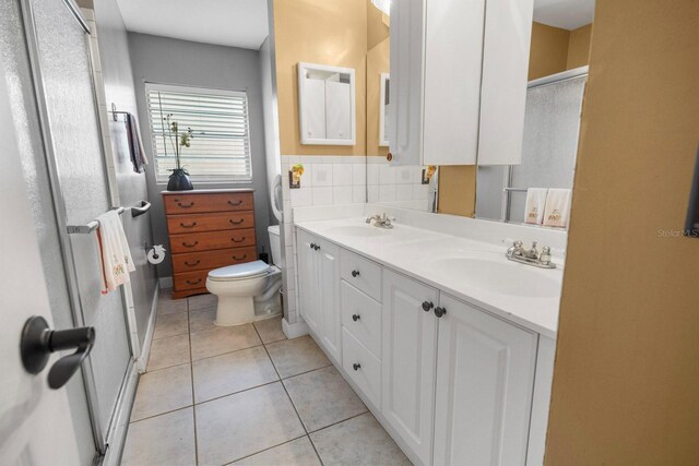 12434 Sullivan Rd, Clermont, FL 34715 - bathroom featuring double vanity, tile patterned flooring, and a shower with door