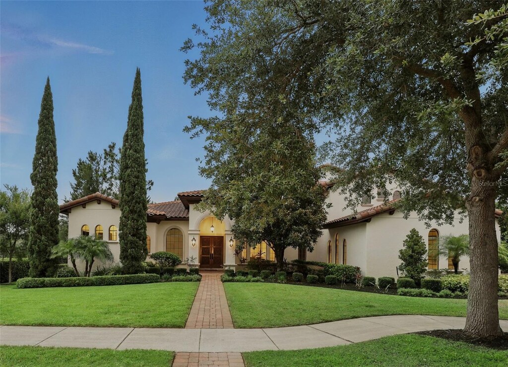 1425 Dunbrooke Loop, Longwood, FL 32779 - mediterranean / spanish-style house with a front yard, stucco siding, and a tile roof