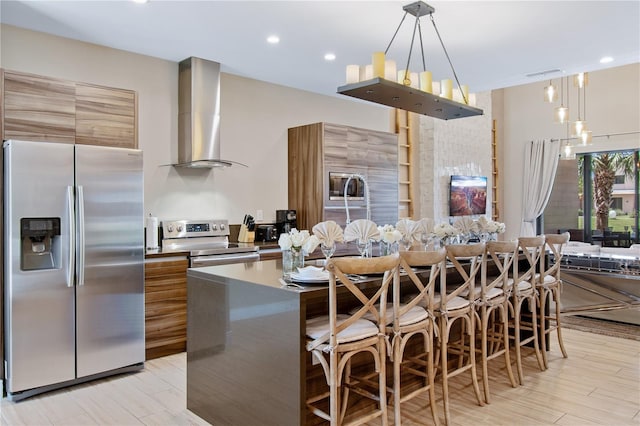 7461 Bleecker Ln, Kissimmee, FL 34747 - kitchen featuring stainless steel refrigerator with ice dispenser, electric range, wall chimney range hood, modern cabinets, and a breakfast bar