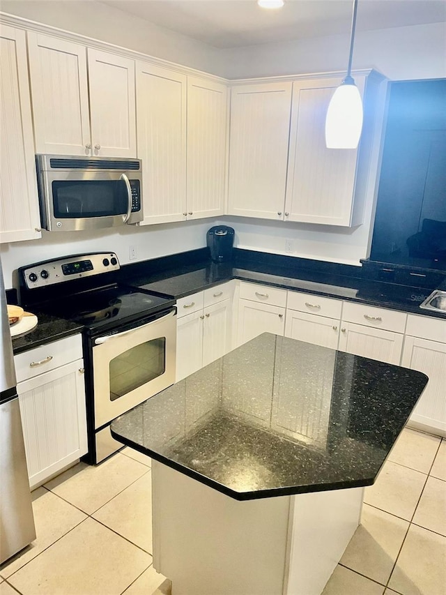 312 Partridge Pea Ln, Ocoee, FL 34761 - kitchen featuring stainless steel appliances, light tile patterned floors, white cabinets, a center island, and decorative light fixtures