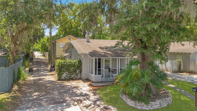 1201 S Myrtle Ave, Sanford, FL 32771 - view of front facade featuring a shingled roof, a chimney, stucco siding, and covered porch
