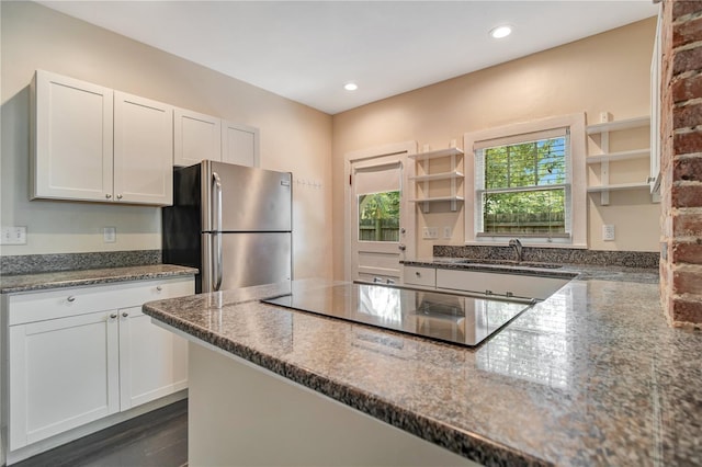 1201 S Myrtle Ave, Sanford, FL 32771 - kitchen with freestanding refrigerator, open shelves, black electric cooktop, dark stone counters, and white cabinets