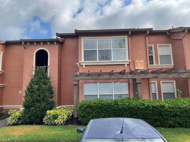5116 Conroy Rd Unit 411, Orlando, FL 32811 - view of front facade with stucco siding and a pergola