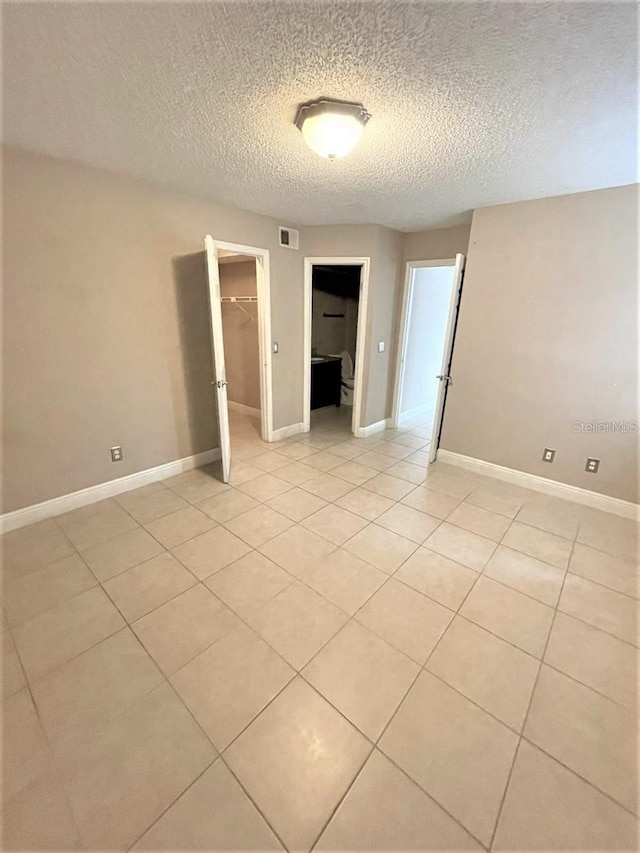 5116 Conroy Rd Unit 411, Orlando, FL 32811 - empty room featuring light tile patterned floors, a textured ceiling, and baseboards