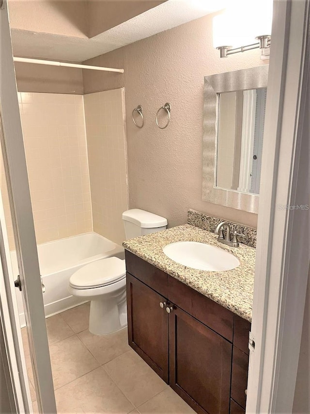 5116 Conroy Rd Unit 411, Orlando, FL 32811 - bathroom featuring a textured wall, vanity, toilet, tile patterned floors, and shower / washtub combination
