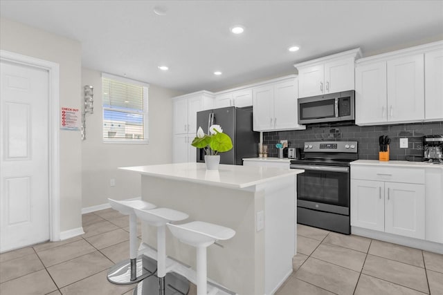 3180 Paradox Cir Unit 304, Kissimmee, FL 34746 - kitchen with stainless steel appliances, a center island, white cabinetry, decorative backsplash, and recessed lighting