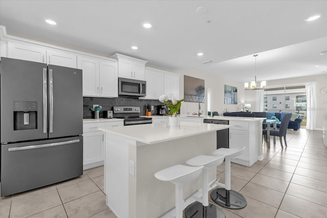 3180 Paradox Cir Unit 304, Kissimmee, FL 34746 - kitchen with appliances with stainless steel finishes, a peninsula, white cabinetry, a kitchen island, and recessed lighting