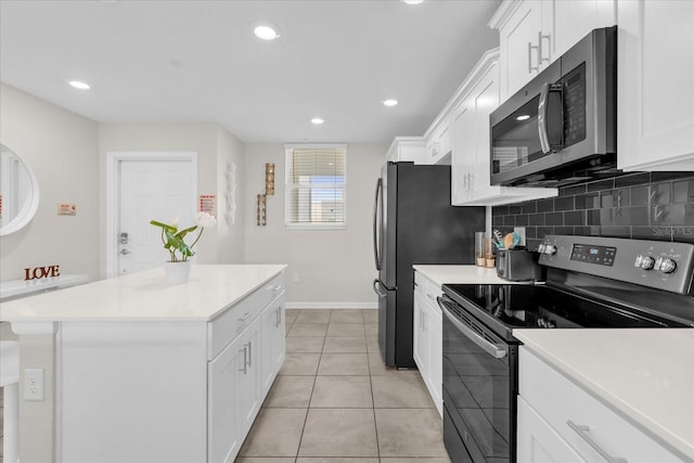 3180 Paradox Cir Unit 304, Kissimmee, FL 34746 - kitchen featuring stainless steel appliances, white cabinetry, a kitchen island, tasteful backsplash, and light countertops