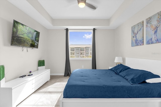 3180 Paradox Cir Unit 304, Kissimmee, FL 34746 - bedroom with light tile patterned floors, a raised ceiling, and a ceiling fan