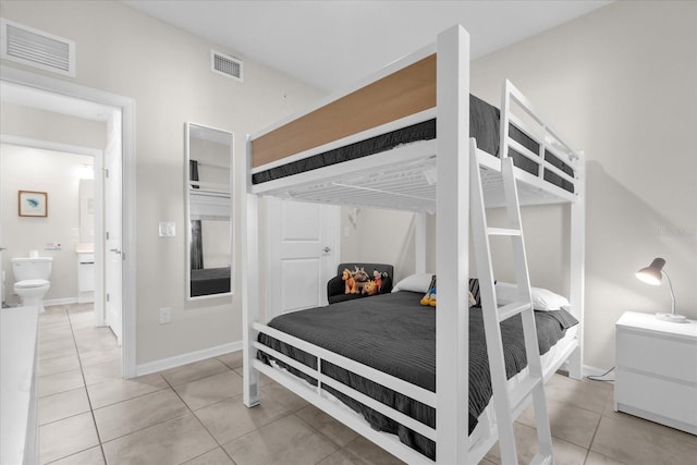 3180 Paradox Cir Unit 304, Kissimmee, FL 34746 - bedroom featuring light tile patterned floors, ensuite bathroom, and baseboards