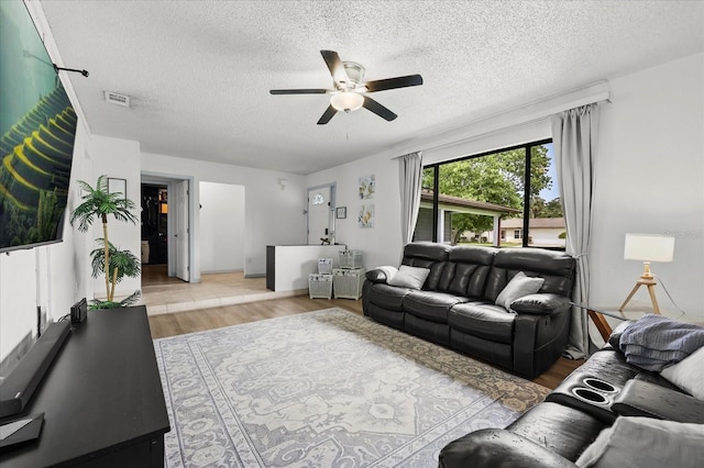 930 Chickadee Dr, Port Orange, FL 32127 - living room featuring light wood-style flooring, a ceiling fan, and a textured ceiling