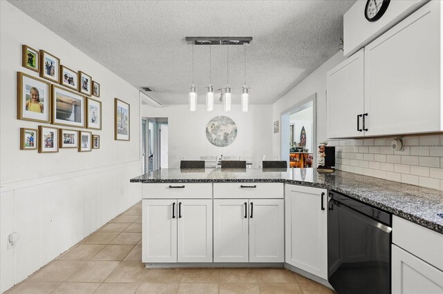 930 Chickadee Dr, Port Orange, FL 32127 - kitchen featuring dishwashing machine, a peninsula, dark stone counters, white cabinetry, and light tile patterned floors