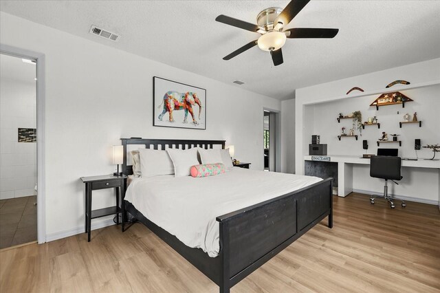 930 Chickadee Dr, Port Orange, FL 32127 - bedroom with wood finished floors, a textured ceiling, ceiling fan, and ensuite bath