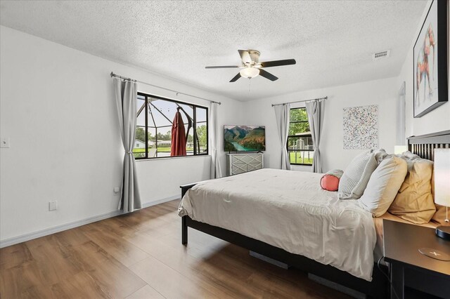 930 Chickadee Dr, Port Orange, FL 32127 - bedroom featuring wood finished floors, a textured ceiling, ceiling fan, and baseboards