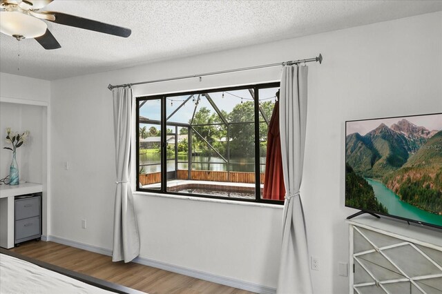 930 Chickadee Dr, Port Orange, FL 32127 - unfurnished bedroom with wood finished floors, a textured ceiling, a ceiling fan, and baseboards