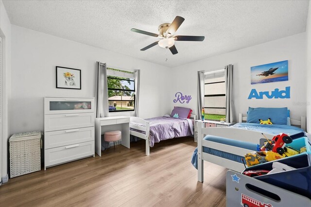 930 Chickadee Dr, Port Orange, FL 32127 - bedroom featuring light wood-style floors, a textured ceiling, and a ceiling fan