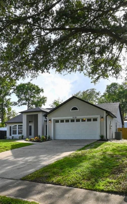 5118 Log Wagon Rd, Ocoee, FL 34761 - view of front of house with concrete driveway, a garage, a front yard, and stucco siding
