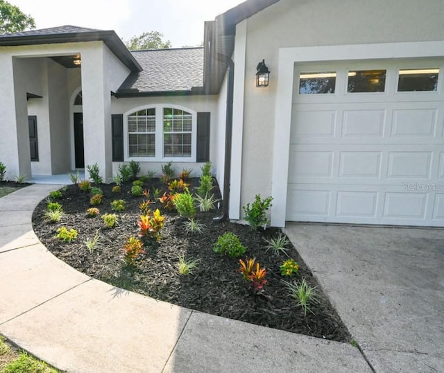 5118 Log Wagon Rd, Ocoee, FL 34761 - entrance to property featuring stucco siding, a garage, concrete driveway, and roof with shingles