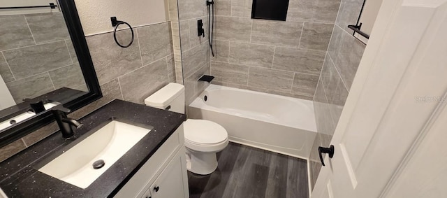 5118 Log Wagon Rd, Ocoee, FL 34761 - bathroom featuring toilet, vanity, washtub / shower combination, wood finished floors, and tile walls