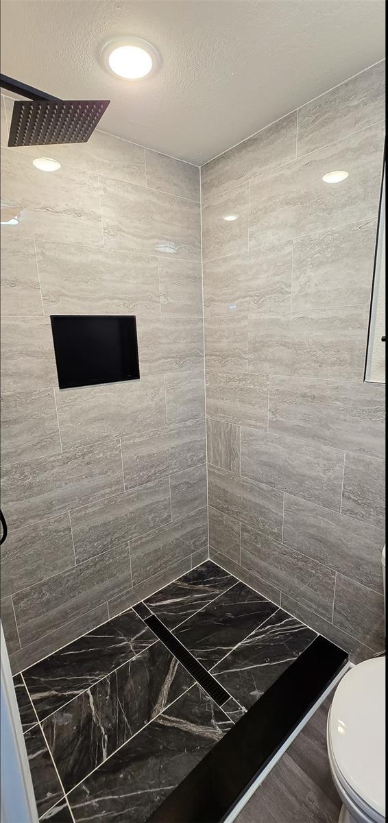 5118 Log Wagon Rd, Ocoee, FL 34761 - full bathroom featuring a tile shower and toilet