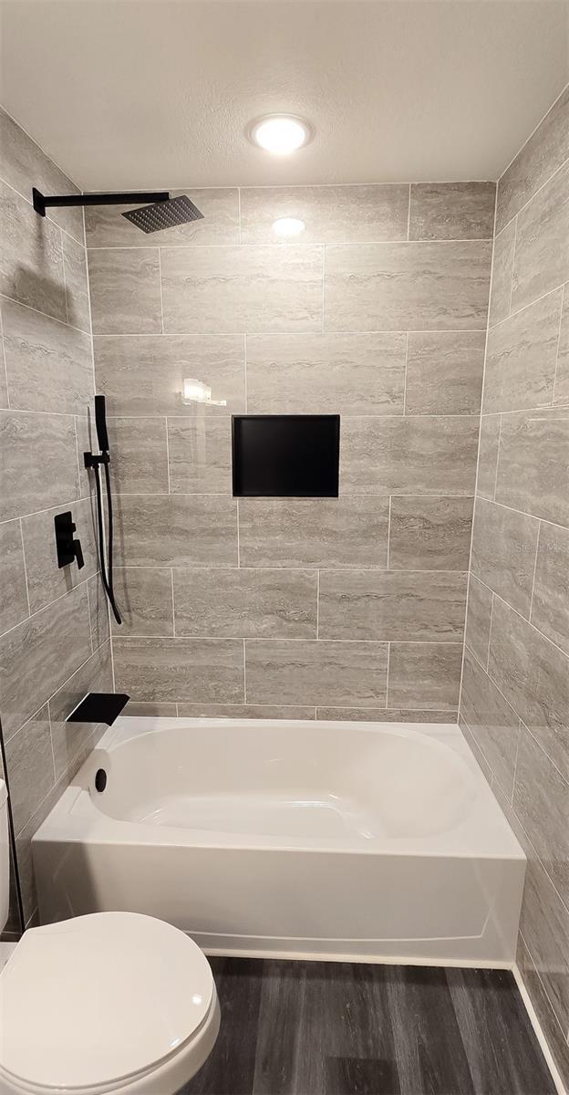 5118 Log Wagon Rd, Ocoee, FL 34761 - bathroom with toilet, wood finished floors, and shower / tub combination