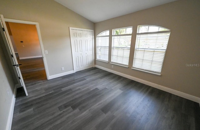 5118 Log Wagon Rd, Ocoee, FL 34761 - unfurnished bedroom with baseboards, dark wood finished floors, vaulted ceiling, and a closet