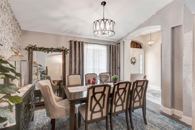 10711 Lake Hill Dr, Clermont, FL 34711 - dining space with a chandelier, wood finished floors, arched walkways, and a textured ceiling