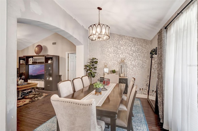 10711 Lake Hill Dr, Clermont, FL 34711 - dining room featuring dark wood finished floors, arched walkways, wallpapered walls, and a chandelier
