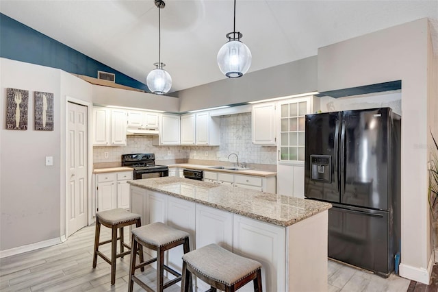 10711 Lake Hill Dr, Clermont, FL 34711 - kitchen with black appliances, decorative backsplash, vaulted ceiling, white cabinetry, and light wood-style floors