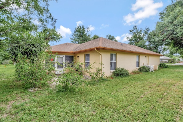 10711 Lake Hill Dr, Clermont, FL 34711 - back of property with stucco siding and a lawn