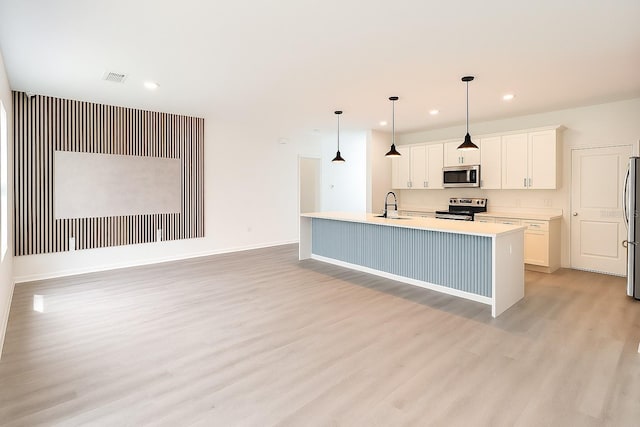 313 Bass Ct, Kissimmee, FL 34759 - kitchen with stainless steel appliances, light wood-style flooring, white cabinetry, light countertops, and recessed lighting