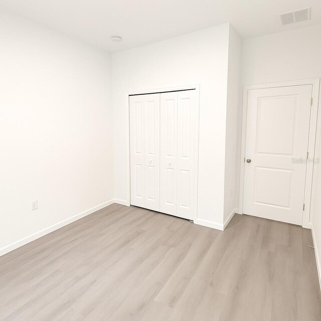 313 Bass Ct, Kissimmee, FL 34759 - unfurnished bedroom with light wood-style flooring and a closet