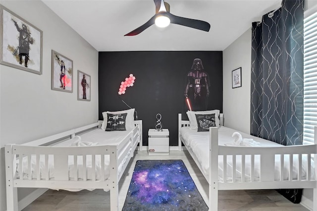 720 Gardenia Ln, Davenport, FL 33897 - bedroom featuring an accent wall, wood finished floors, and ceiling fan