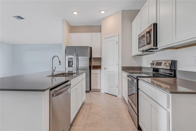 865 Citrus Reserve Blvd, Davenport, FL 33837 - kitchen featuring stainless steel appliances, a sink, dark countertops, white cabinetry, and a center island with sink
