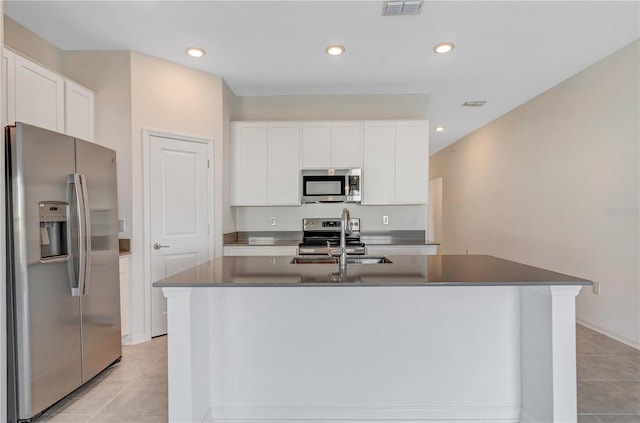 865 Citrus Reserve Blvd, Davenport, FL 33837 - kitchen with stainless steel appliances, light tile patterned flooring, a sink, white cabinets, and a center island with sink