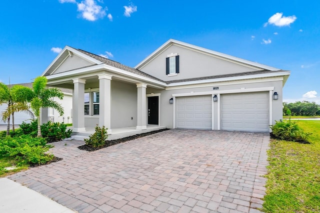 1596 Contentment Loop, Kissimmee, FL 34744 - neoclassical / greek revival house featuring stucco siding, decorative driveway, covered porch, and an attached garage